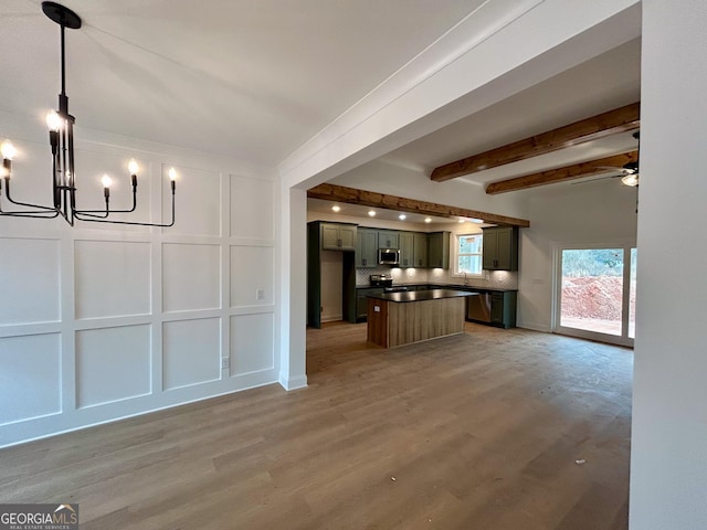 unfurnished living room featuring beam ceiling, ceiling fan with notable chandelier, and hardwood / wood-style flooring