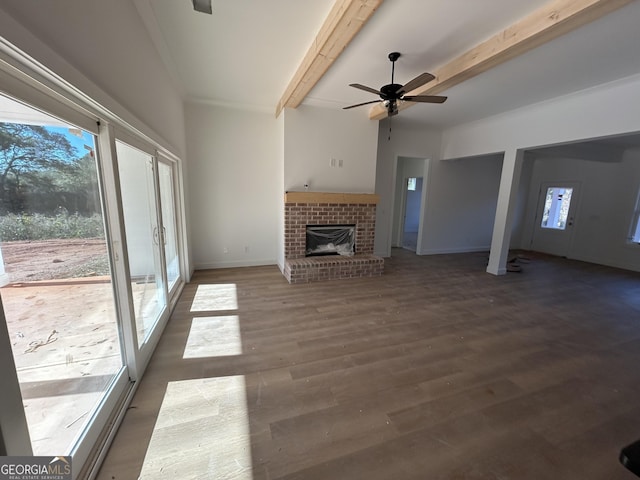 unfurnished living room with dark hardwood / wood-style flooring, a healthy amount of sunlight, and beam ceiling