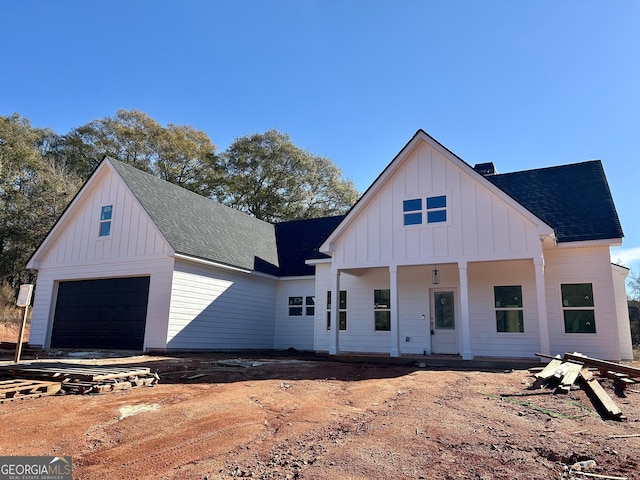 modern inspired farmhouse with a garage and a porch