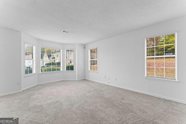 empty room with a textured ceiling and carpet floors