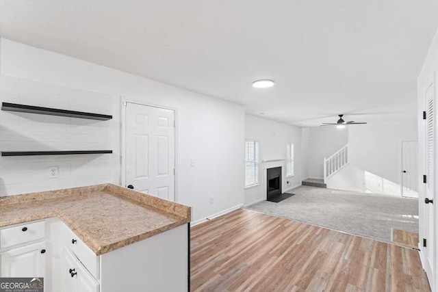 kitchen featuring white cabinetry, light hardwood / wood-style floors, and ceiling fan