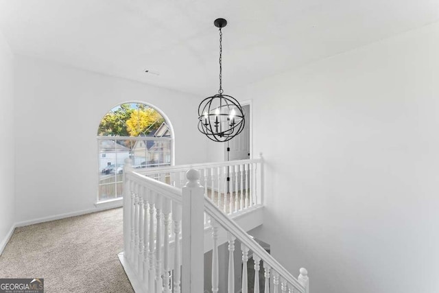 corridor featuring a chandelier and carpet