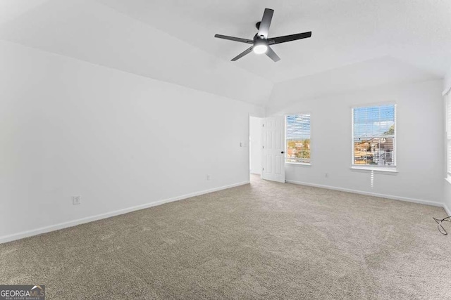 carpeted empty room with ceiling fan and lofted ceiling