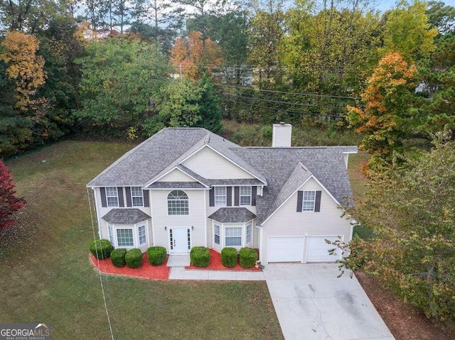 view of front of house with a garage and a front lawn