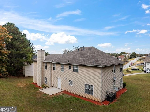 rear view of house with a yard, a patio, and central AC