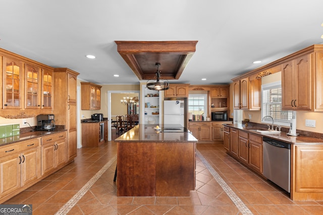 kitchen featuring stainless steel dishwasher, a center island, white fridge, and a wealth of natural light