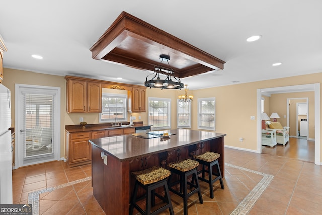 kitchen featuring a breakfast bar area, a center island, hanging light fixtures, and light tile patterned floors