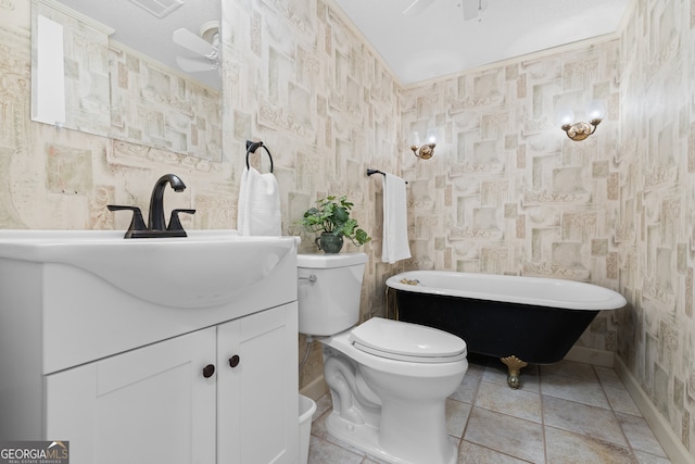 bathroom featuring toilet, vanity, a bathtub, and ceiling fan