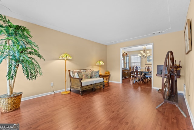 sitting room with a chandelier and wood-type flooring