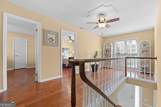 hall featuring hardwood / wood-style floors and a textured ceiling