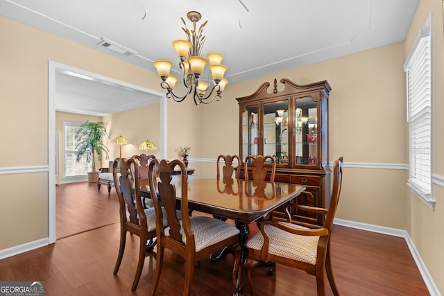 dining space with a chandelier and dark wood-type flooring