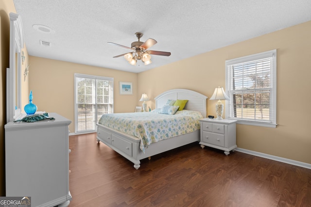 bedroom featuring dark wood-type flooring, multiple windows, and ceiling fan