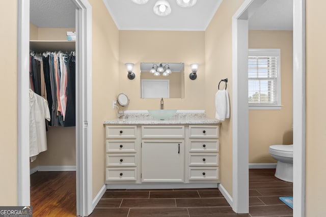 bathroom with vanity, a textured ceiling, and toilet