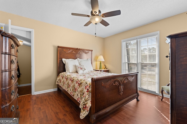 bedroom featuring a textured ceiling, dark wood-type flooring, and ceiling fan