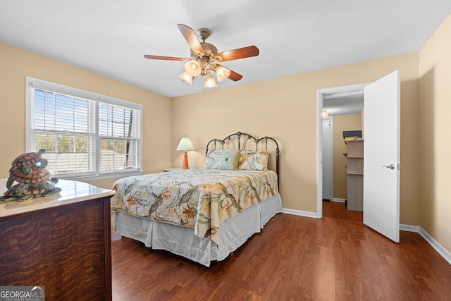 bedroom featuring dark hardwood / wood-style floors, a textured ceiling, and ceiling fan