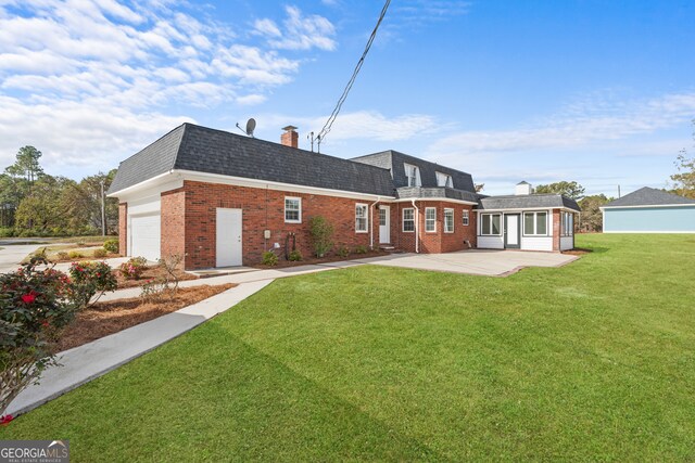 rear view of house with a yard, a patio, and a garage