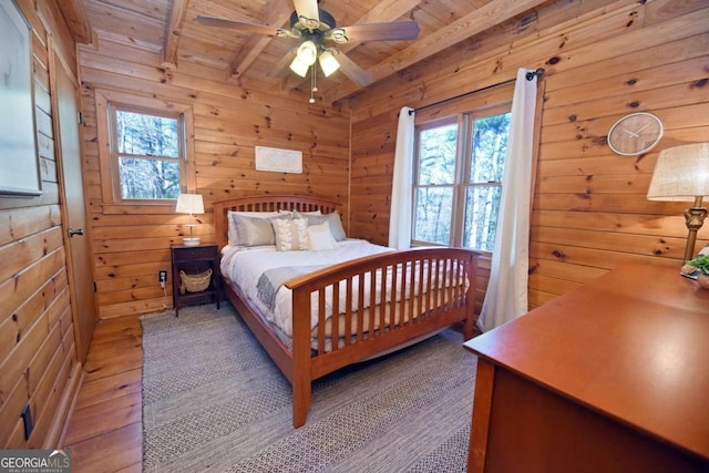 bedroom with wooden walls and beam ceiling