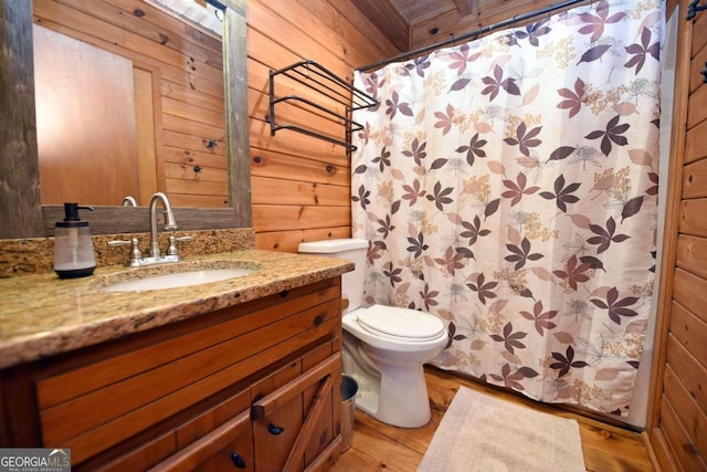 full bathroom with toilet, wood walls, wood finished floors, and vanity