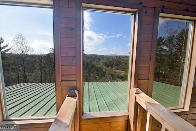 entryway featuring a wealth of natural light and a wooded view