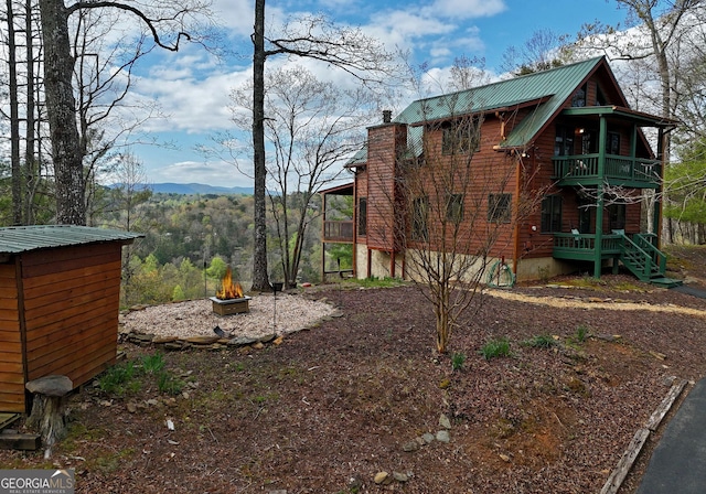 view of yard with a balcony, a mountain view, and an outdoor fire pit