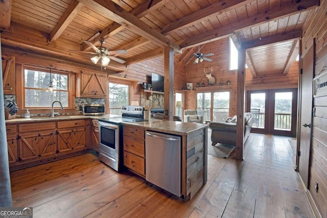 kitchen with appliances with stainless steel finishes, wooden walls, light wood-type flooring, and wooden ceiling