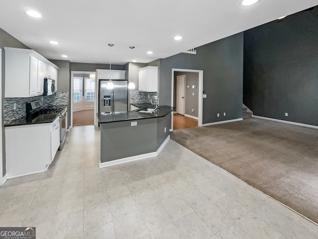 kitchen with decorative backsplash, white cabinets, sink, pendant lighting, and stainless steel appliances