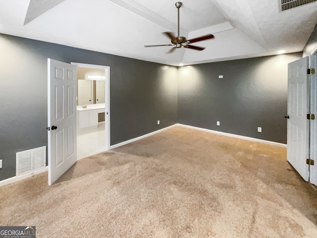 unfurnished bedroom featuring connected bathroom, light colored carpet, and ceiling fan