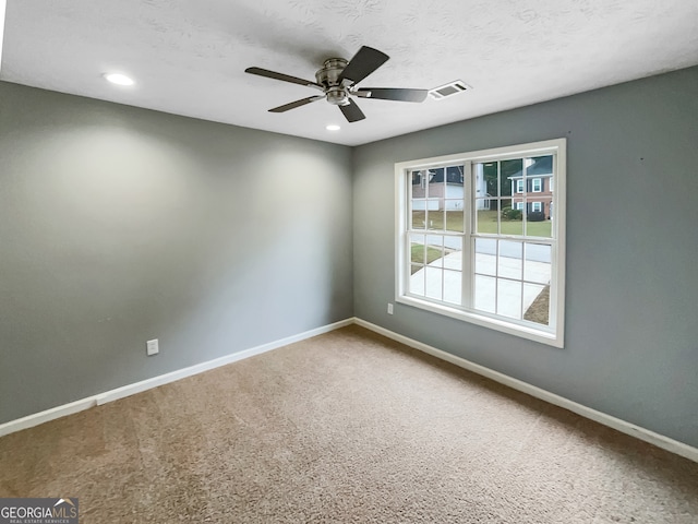 carpeted spare room with ceiling fan