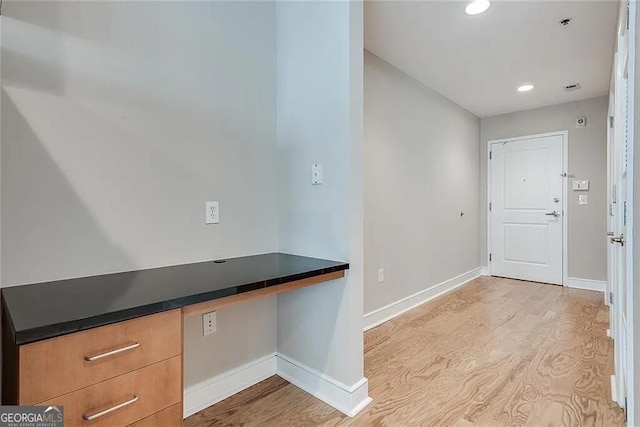 foyer entrance featuring built in desk and light hardwood / wood-style floors