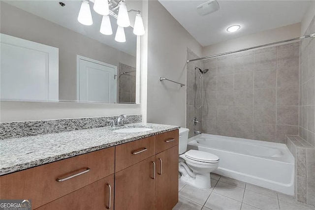 full bathroom with tile patterned flooring, vanity, toilet, and tiled shower / bath