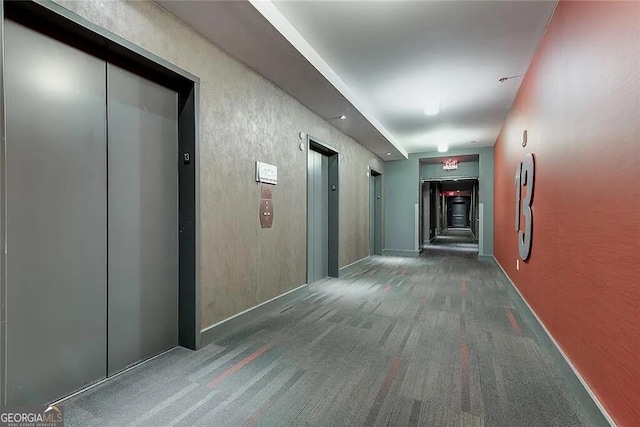 hallway with dark colored carpet and elevator