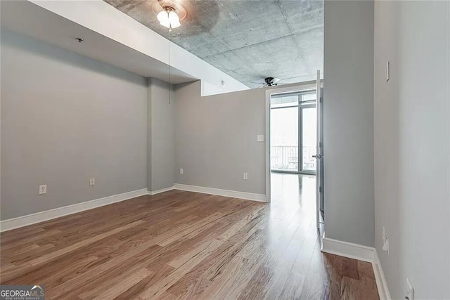 unfurnished room with ceiling fan and wood-type flooring