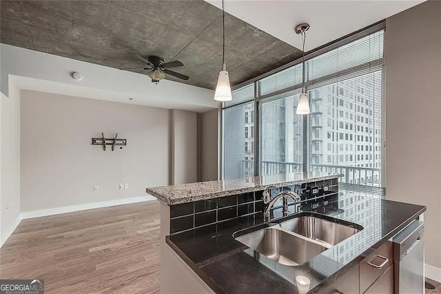 kitchen featuring sink, hanging light fixtures, stainless steel dishwasher, hardwood / wood-style flooring, and ceiling fan