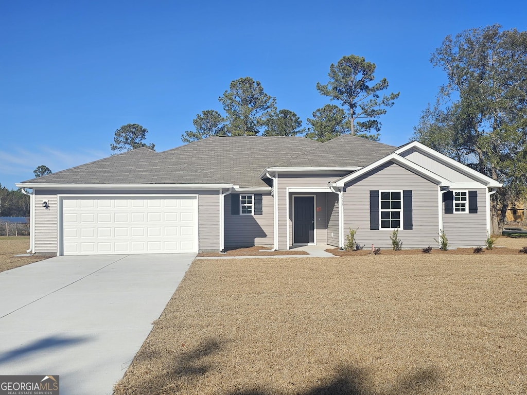 ranch-style house featuring a garage and a front yard