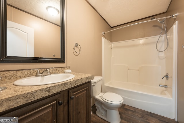 full bathroom with wood-type flooring, a textured ceiling, toilet, vanity, and shower / bathtub combination