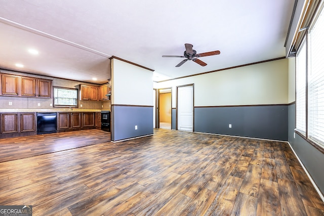 unfurnished living room with ceiling fan, ornamental molding, and dark hardwood / wood-style floors