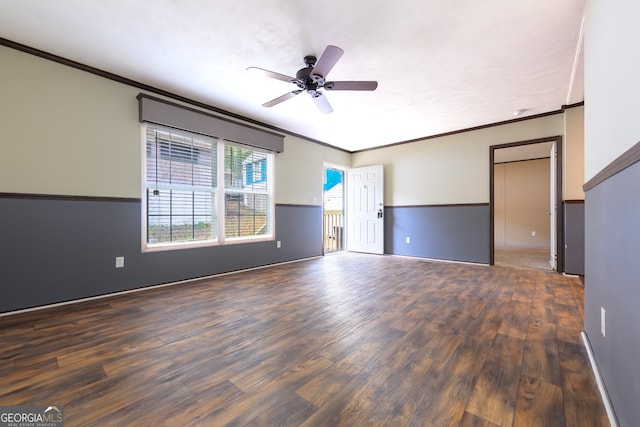 spare room with dark wood-type flooring, crown molding, and ceiling fan