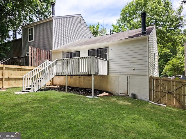 rear view of property featuring stairway, fence, and a lawn