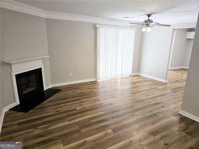 unfurnished living room featuring a textured ceiling, baseboards, a fireplace with raised hearth, and wood finished floors