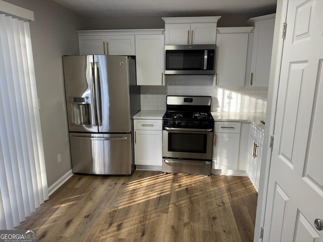 kitchen featuring stainless steel appliances, light countertops, dark wood-type flooring, and tasteful backsplash