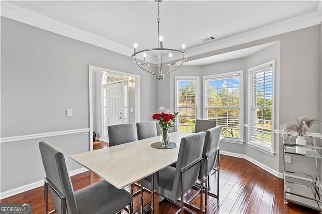 dining room with crown molding, dark hardwood / wood-style flooring, and a notable chandelier