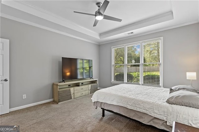 bedroom with carpet flooring, a raised ceiling, ceiling fan, and crown molding