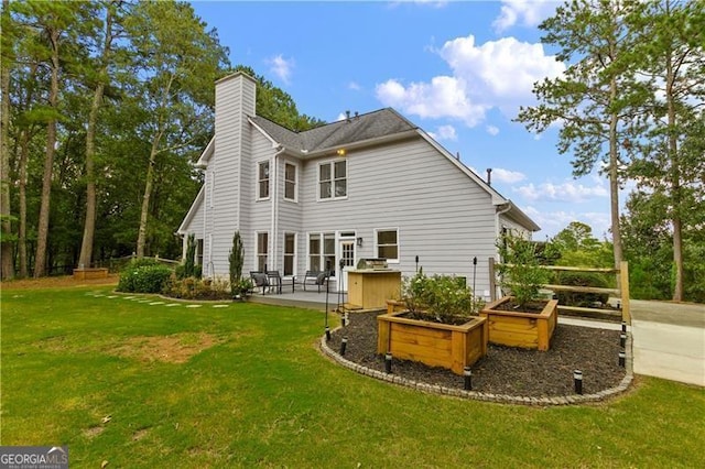 rear view of property with a yard and a patio