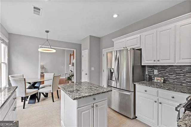 kitchen featuring white cabinets, light stone countertops, decorative light fixtures, a kitchen island, and stainless steel appliances