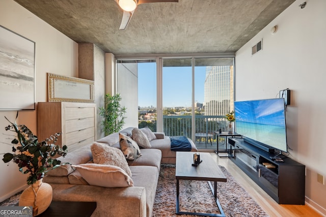 living room with wood-type flooring and ceiling fan