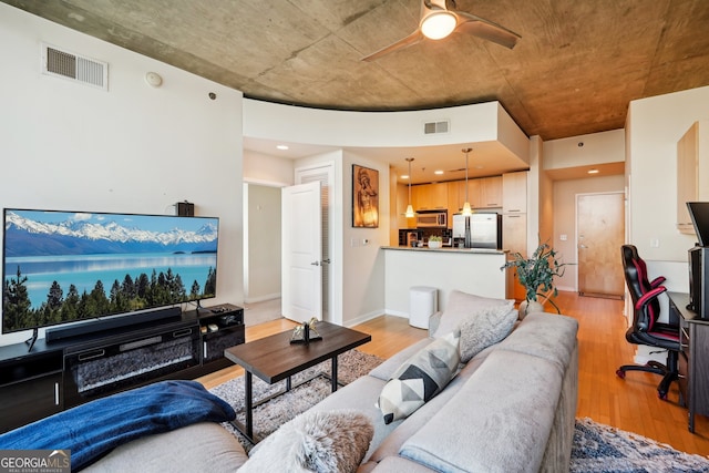 living room featuring light hardwood / wood-style floors and ceiling fan