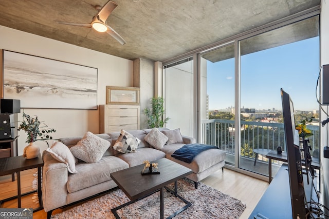 living room with floor to ceiling windows, hardwood / wood-style floors, and ceiling fan