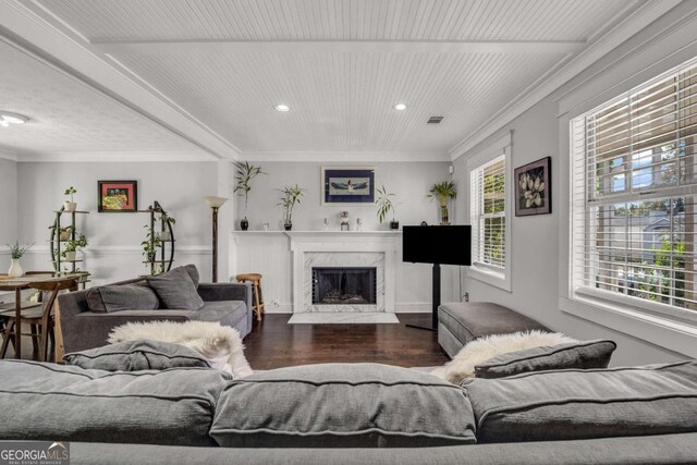 living room with a premium fireplace, crown molding, and dark hardwood / wood-style flooring