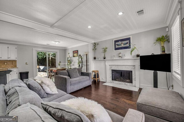 living room with dark wood-type flooring, a fireplace, and crown molding