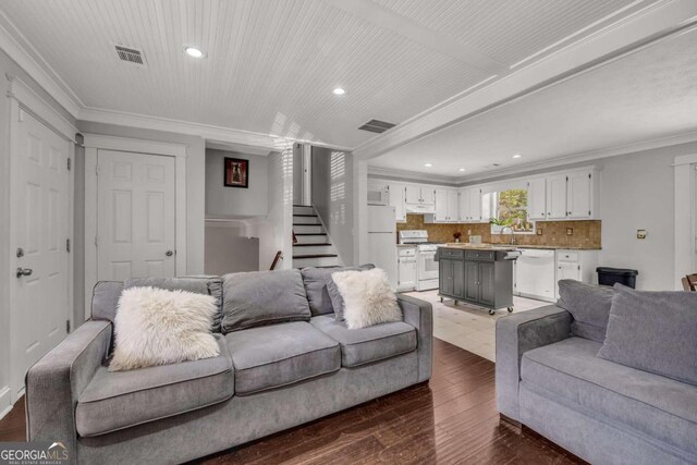 living room featuring ornamental molding, sink, and dark hardwood / wood-style flooring